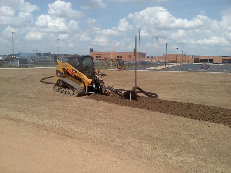 Sock drainage tile injected to exact grade elevations using slit trencher.